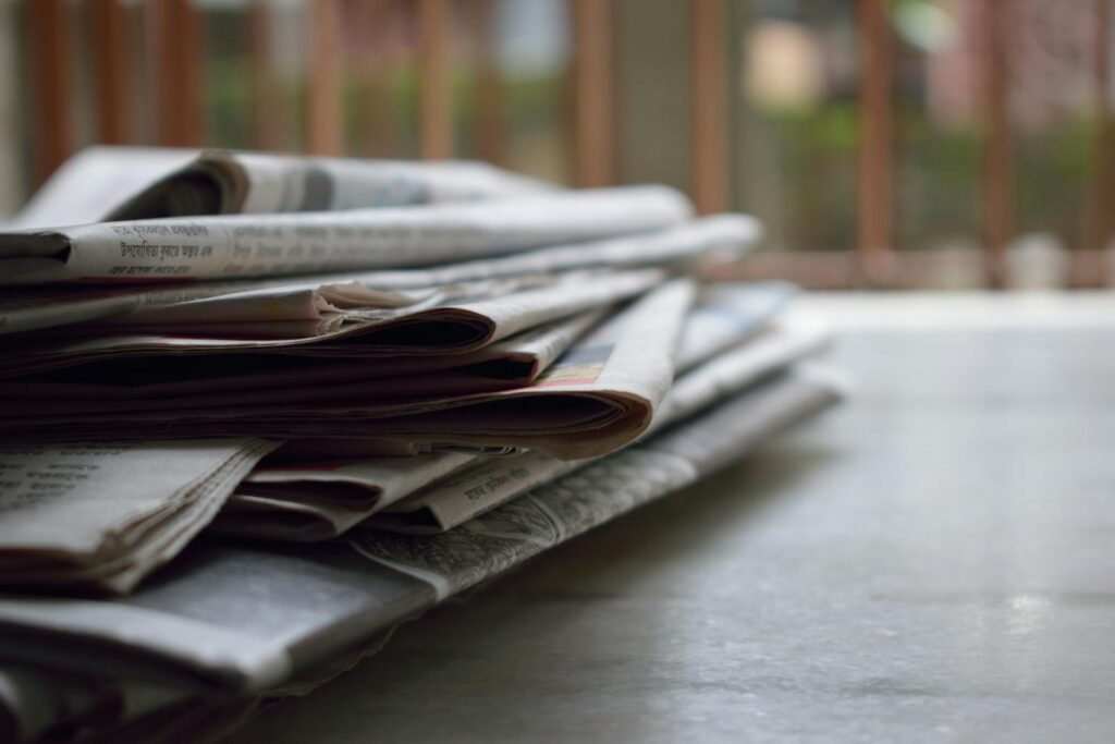 KIDZONET join WeProtect Global Alliance 1 A close-up of a stack of newspapers resting on a desk, symbolizing information and media.
